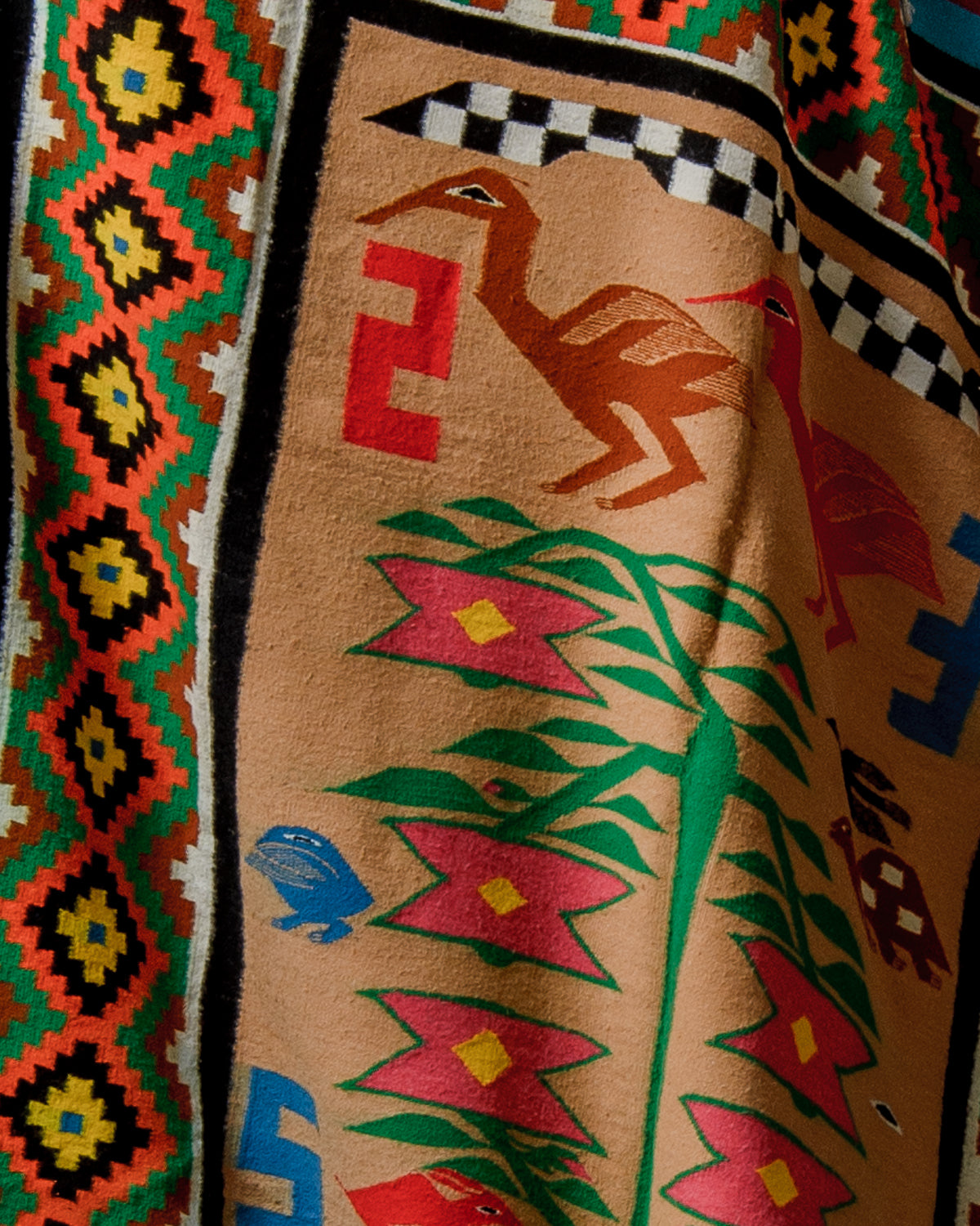 Close-up of a colorful fabric with geometric patterns and animal designs.